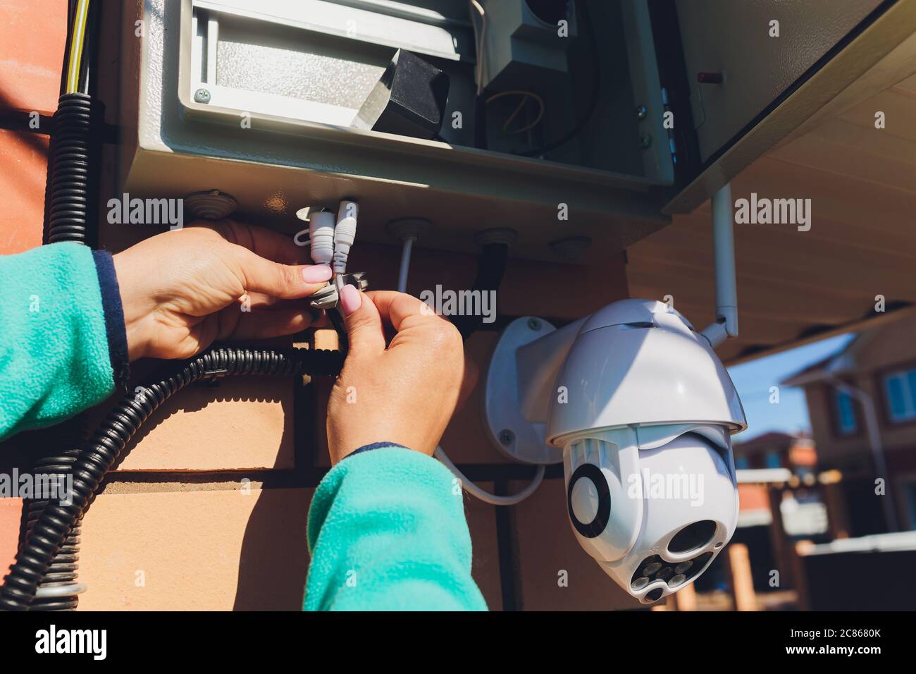technician female setup cctv camera on wall. Stock Photo
