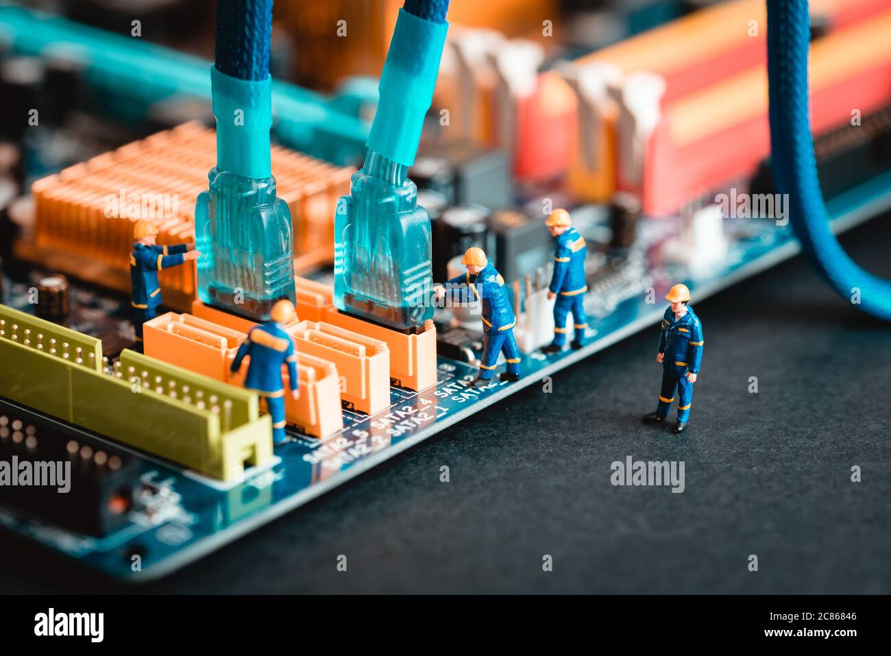 Computer assembly - technicians connecting sata cable on motherboard ...