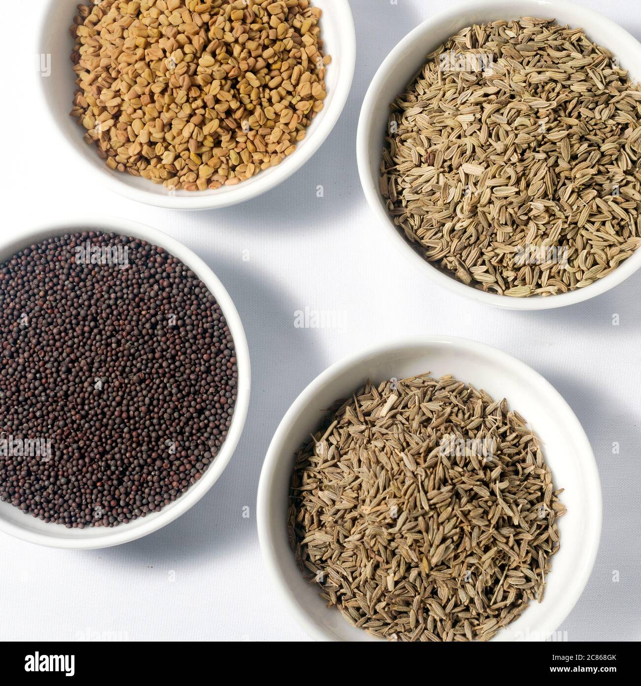 Best of Ceylon Spices; Cumin seeds, Caraway seeds, Mustard seeds, Fenugreek seeds in bowls. Isolated on white background Stock Photo
