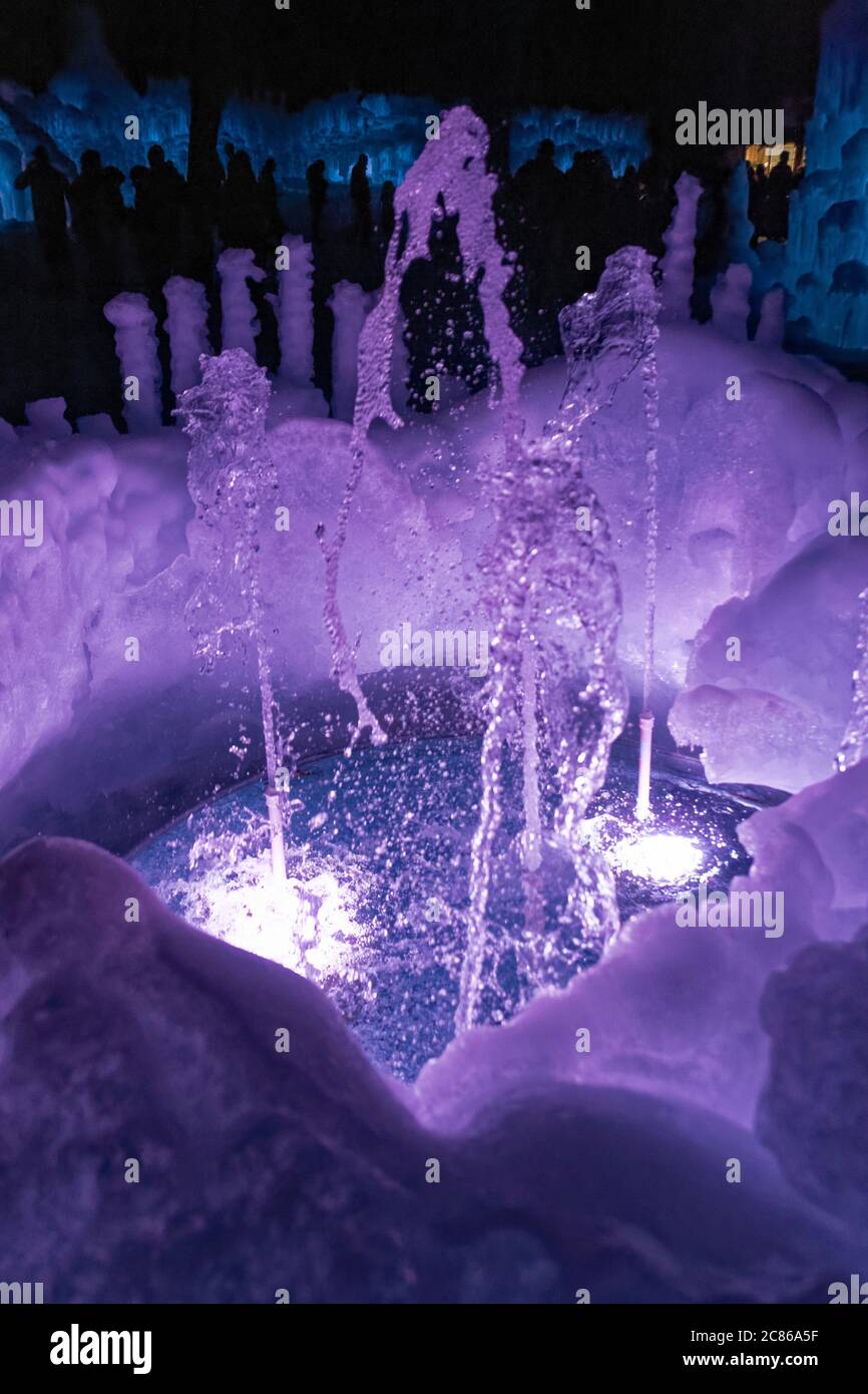 A water fountain made of ice, lit up purple. Stock Photo