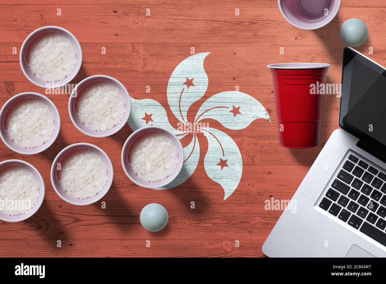 Hong Kong flag concept with plastic beer pong cups and laptop on