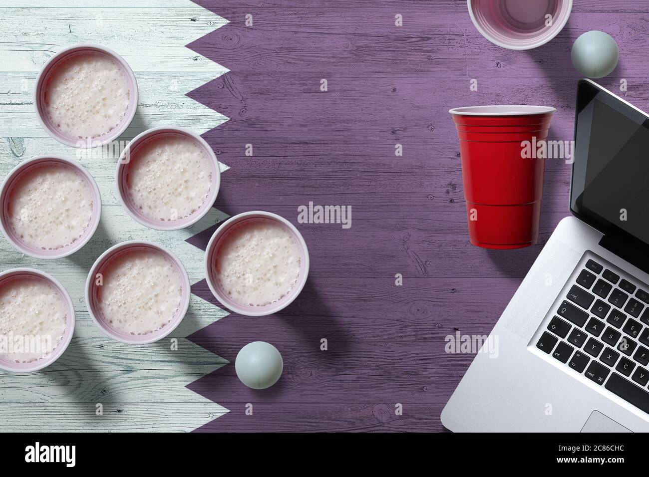 Qatar flag concept with plastic beer pong cups and laptop on national