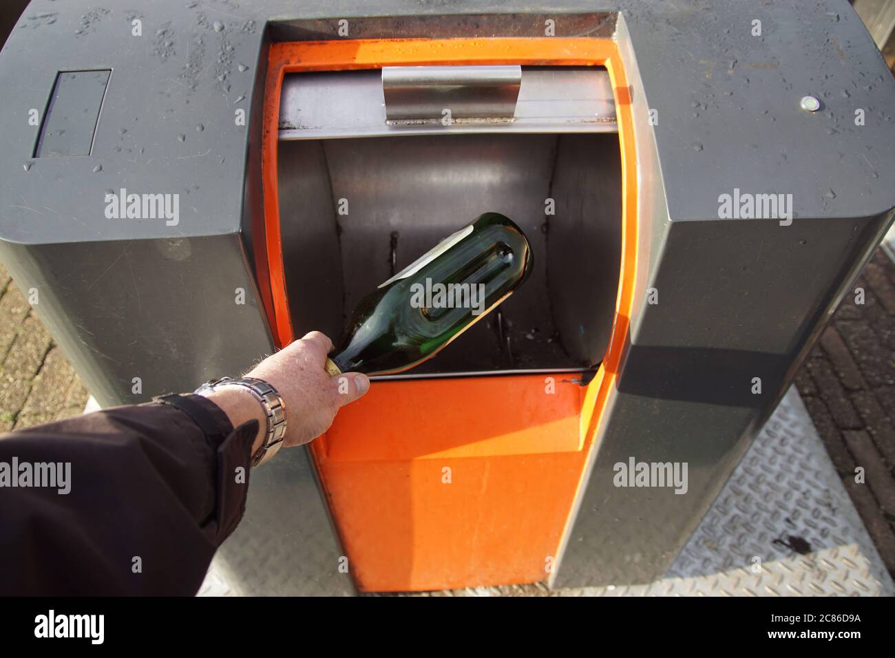 Someone is putting plastic waste in an opened underground waste