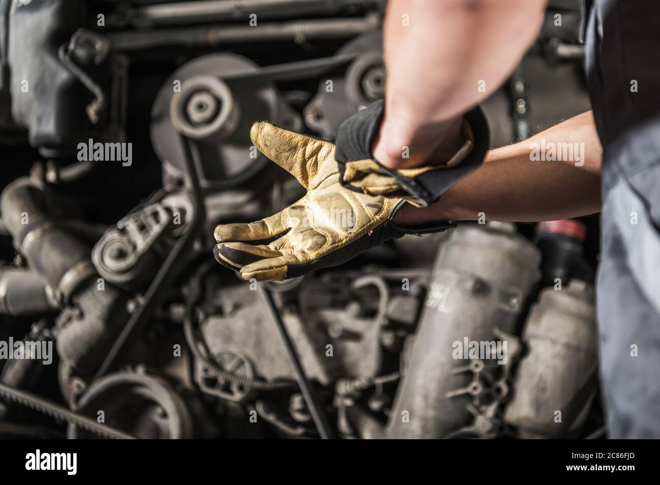 Caucasian Heavy Duty Diesel Engines Mechanic Preparing For Work Wearing Safety Gloves Stock Photo