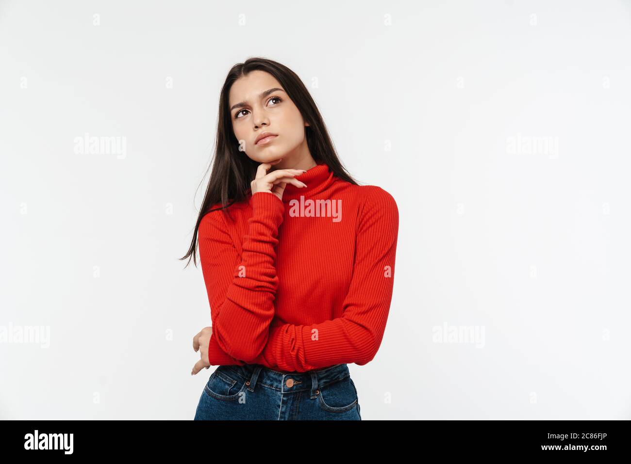 Photo of serious young woman in red sweater posing and looking upward ...