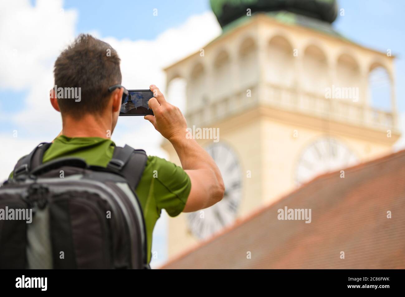 Caucasian Tourist with Large Backpack Taking Travel Pictures Using His Smartphone Device. Stock Photo