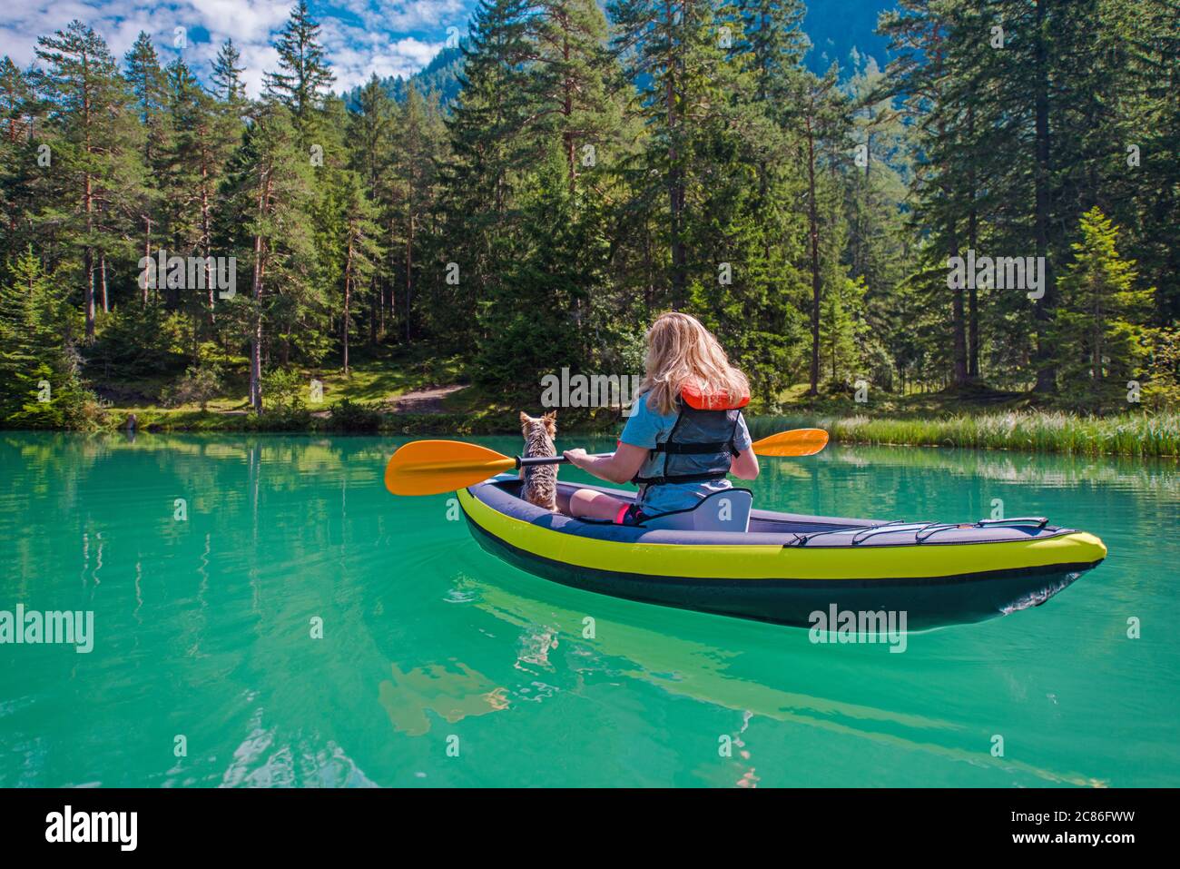 Caucasian Woman in Her 30s Kayaking with Her Australian Silky Terrier Dog on Scenic Turquoise Water Austrian Lake. Kayak Recreation Theme. Stock Photo