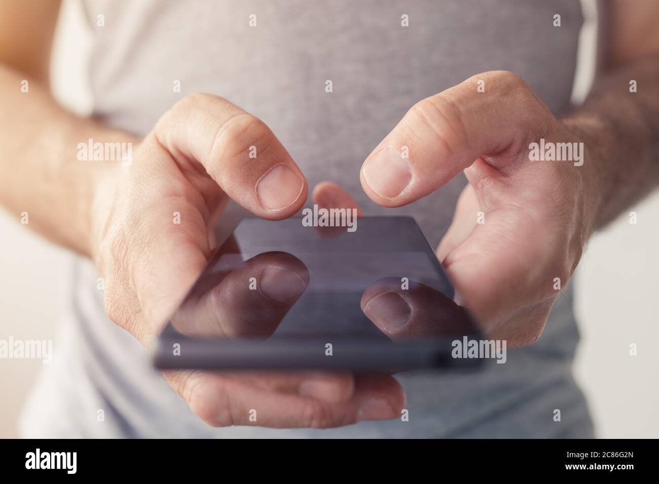Close up of male hands typing text message on smartphone, selective focus Stock Photo