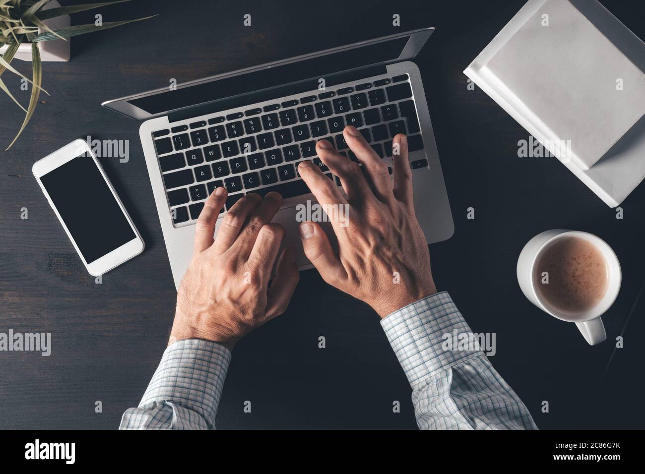 Businessman typing laptop computer keyboard, top view of office desk in morning Stock Photo