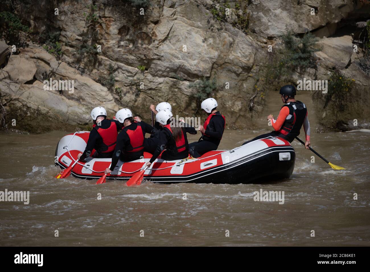 Instructor and team practicing rafting down the river as a seasonal adventure. Extreme sports for family and friends Stock Photo