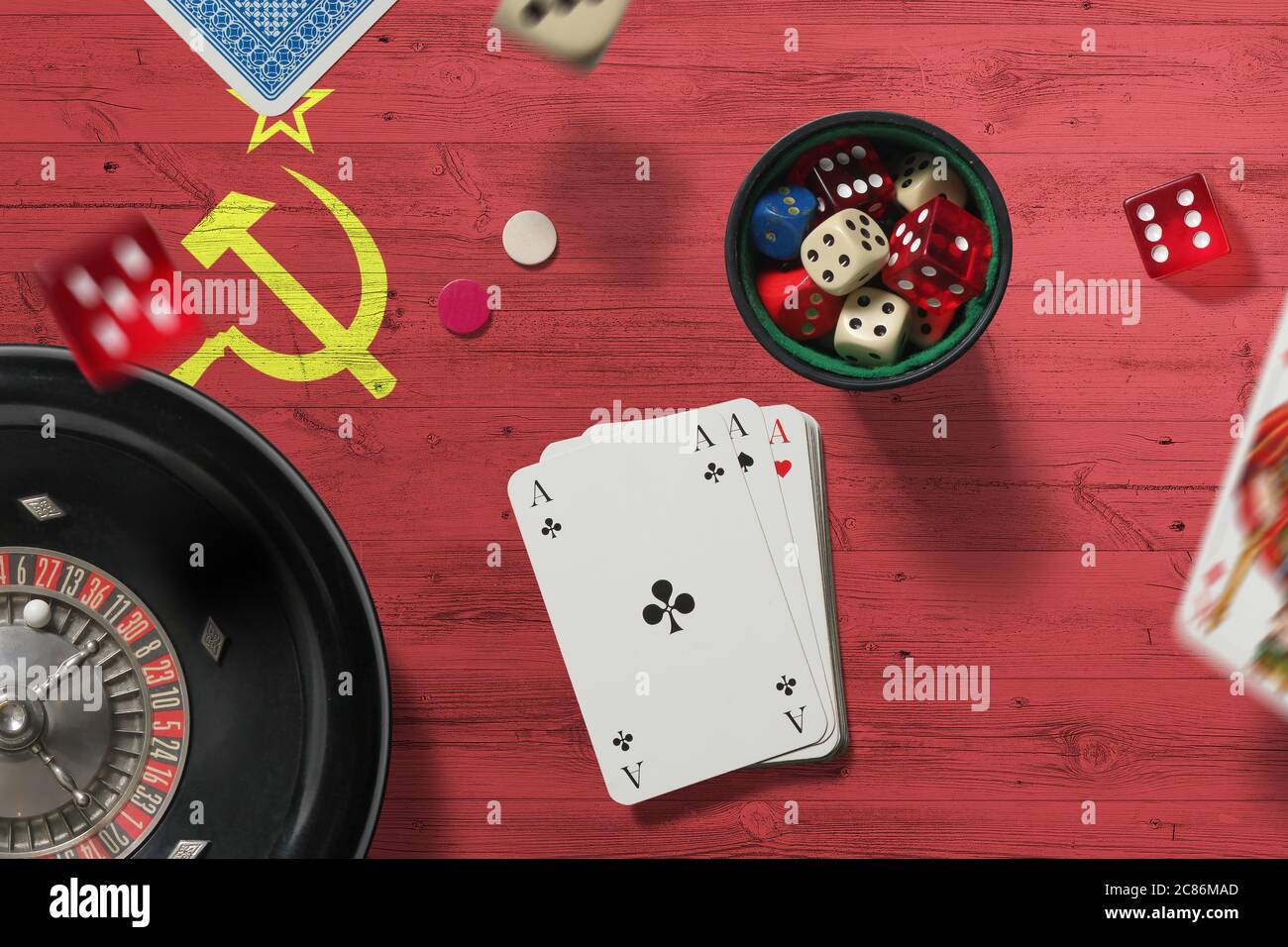 Soviet Union casino theme. Aces in poker game, cards and chips on red table with national flag background. Gambling and betting. Stock Photo