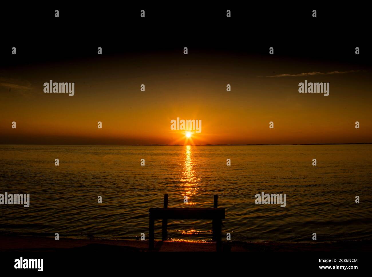 Setting sun spreads over river water. Stock Photo