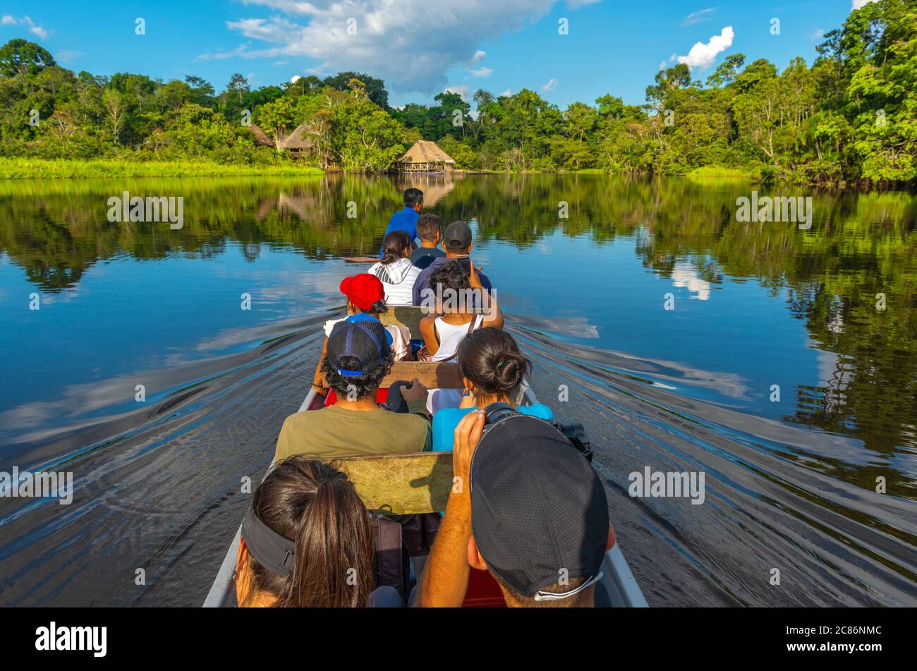 A group of tourists arriving in the Amazon Rainforest by Canoe, Yasuni nationak park, Ecuador. Stock Photo