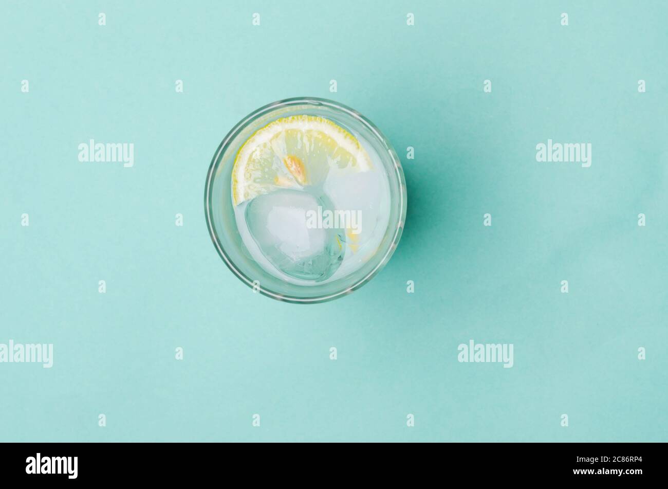Cocktail with ice and lemon slice on bright blue background Stock Photo ...