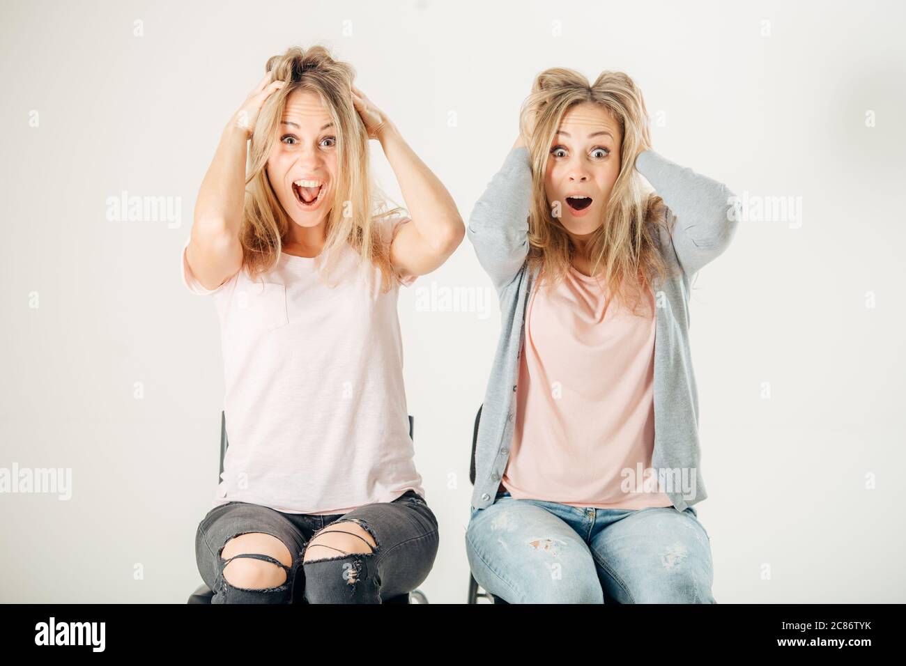Surprised girl looking at camera. sister twin over white background Stock  Photo - Alamy