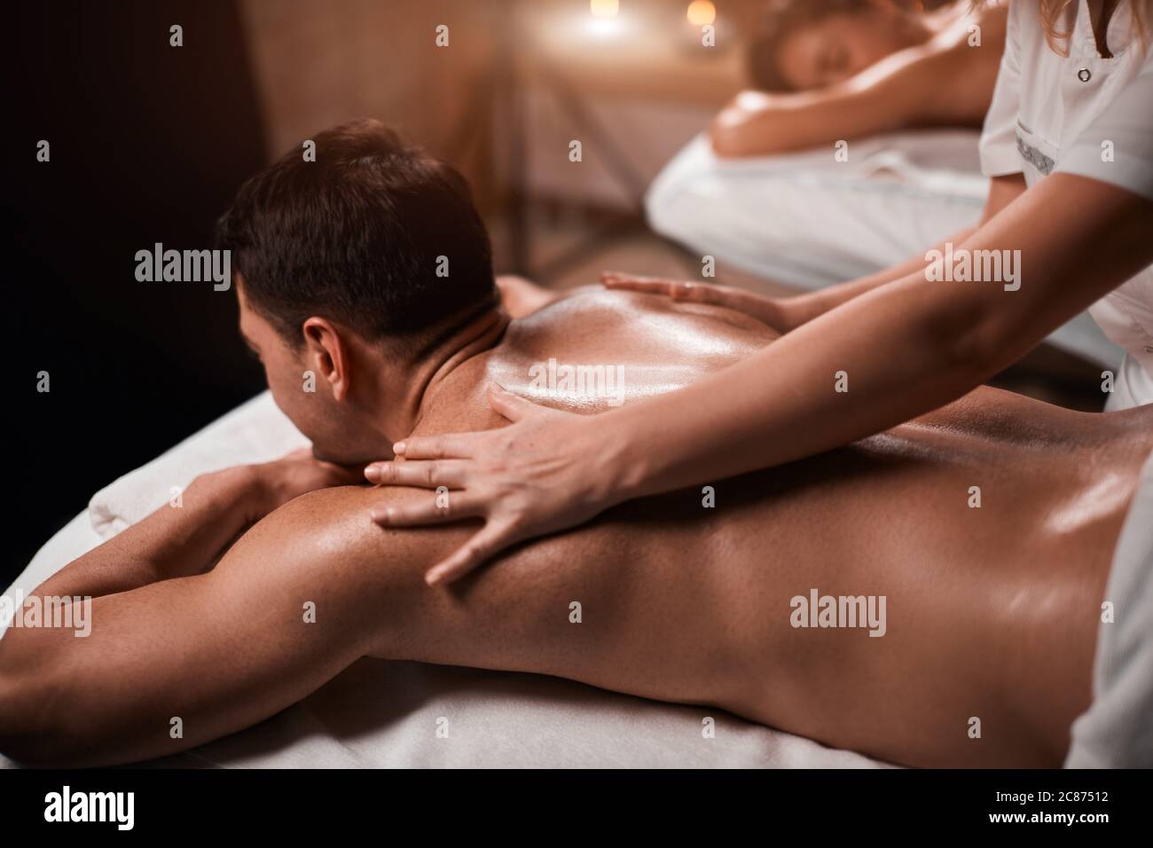 Handsome caucasian businessman and his beautiful wife treating themselves to a comforting back massage, a gentle relaxing massage at spa clinic Stock Photo pic