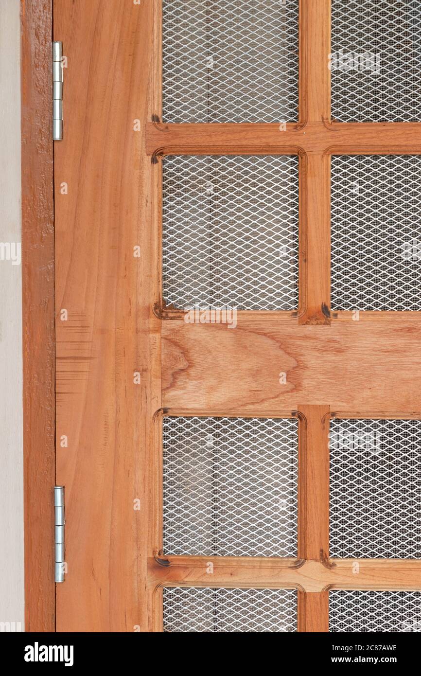 Steel door hinges fitted on wooden net grill door, close up view Stock Photo