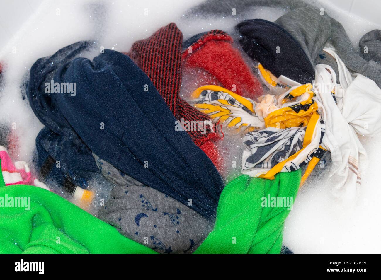 Soaking color clothes in washing powder, household chores Stock Photo