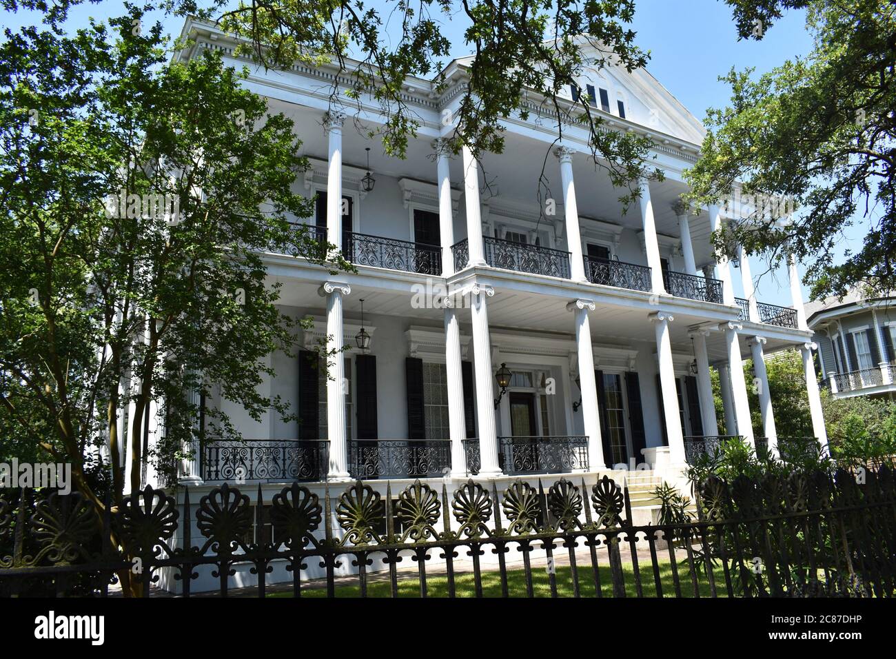 The Buckner Mansion in the Garden District of New Orleans.  The mansion was featured in American Horror Story Coven. White mansion with ironwork fence. Stock Photo