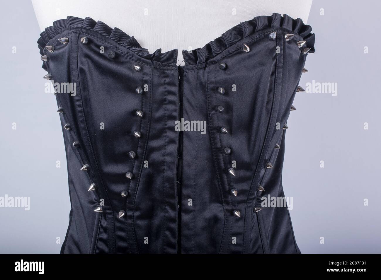 A Tailors Mannequin dressed in a Black Corset with Spikes Stock Photo