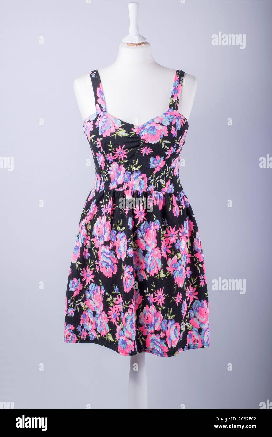 A Tailors Mannequin dressed in a Black and Pink Floral Dress Stock Photo