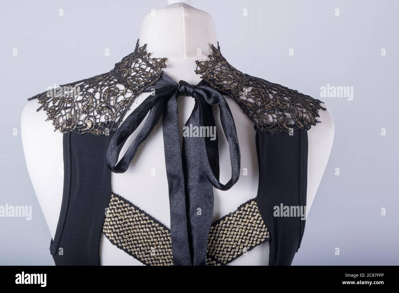 A Tailors Mannequin dressed in a Black and Gold Lace Dress Stock Photo