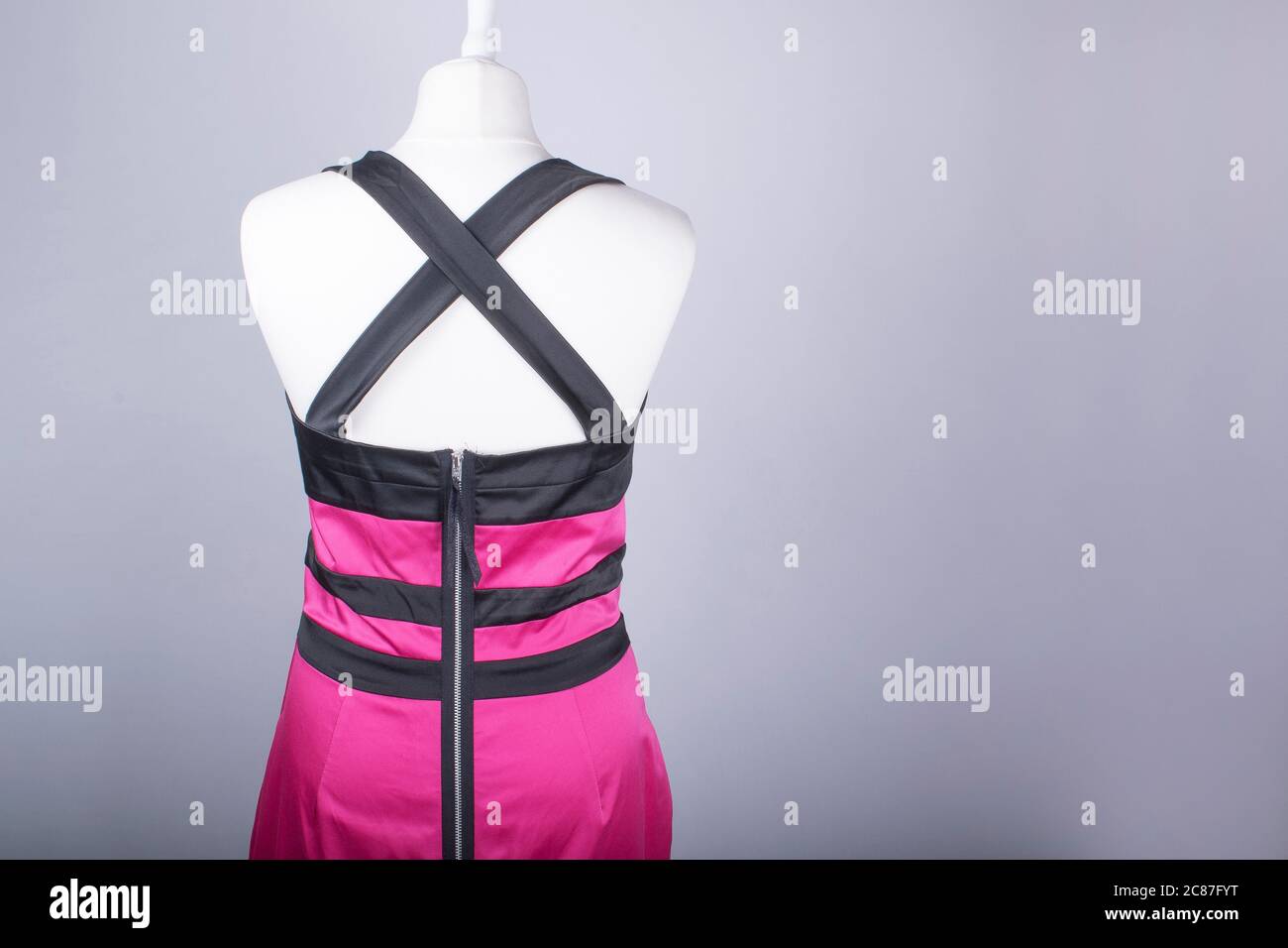 A Tailors Mannequin dressed in a Pink and Black Satin Dress Stock Photo