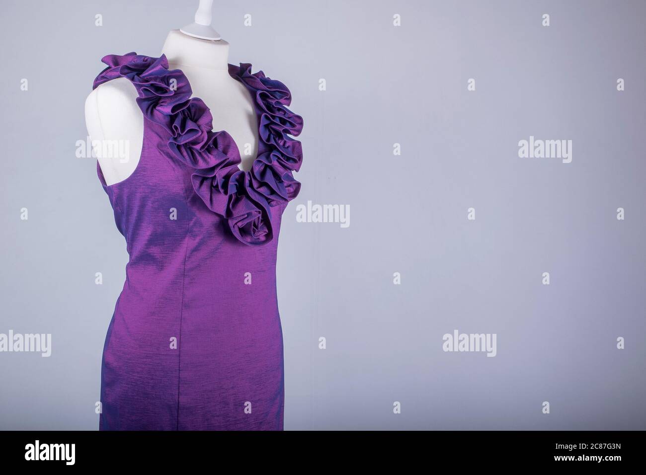 A Tailors Mannequin dressed in a Purple Ruffle Dress Stock Photo