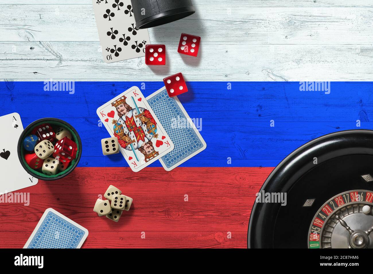 Russia casino theme. Aces in poker game, cards and chips on red table with national wooden flag background. Gambling and betting. Stock Photo