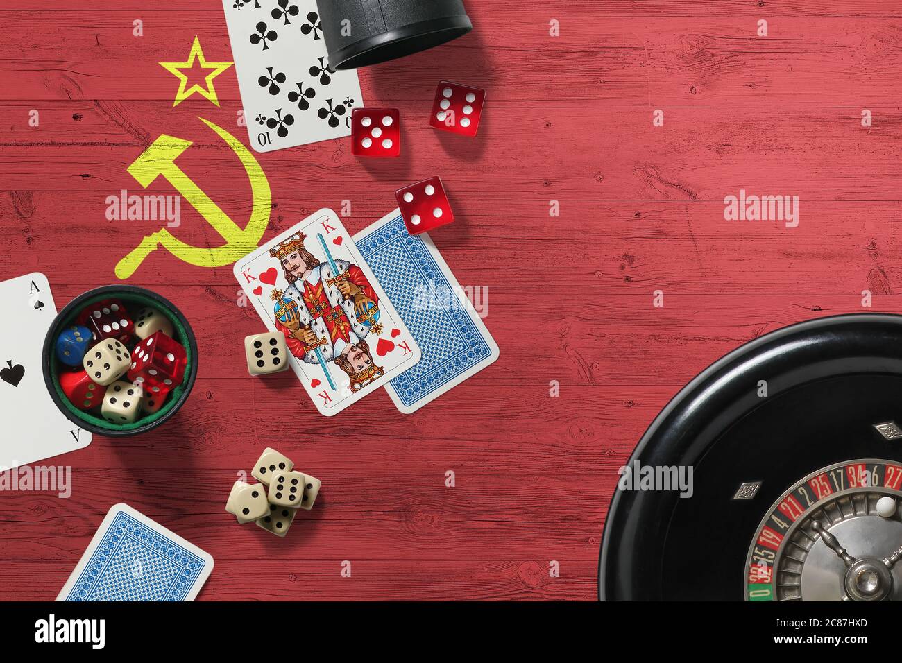 Soviet Union casino theme. Aces in poker game, cards and chips on red table with national wooden flag background. Gambling and betting. Stock Photo