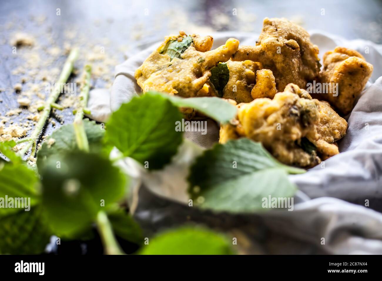 Close up shot of monsoon snack ajwain pakora in a container along with