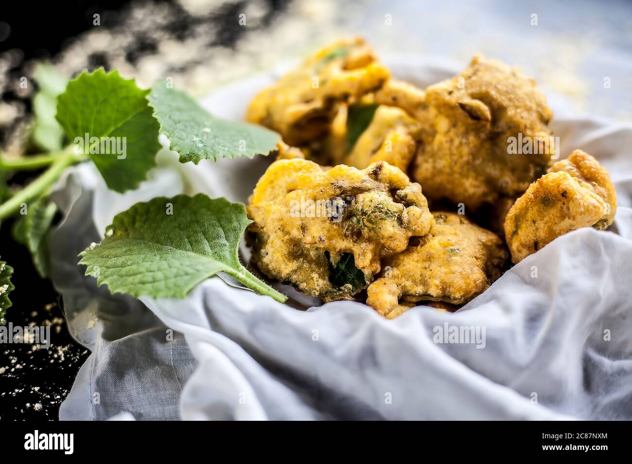 Close up shot of monsoon snack ajwain pakora in a container along with