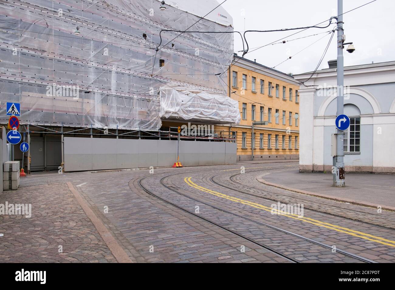 An old building is covered, wrapped in construction site safety fabric. In Helsinki, Finland. Stock Photo