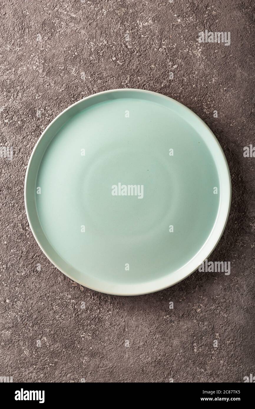 Ceramic empty plate on grey concrete background. Stock Photo