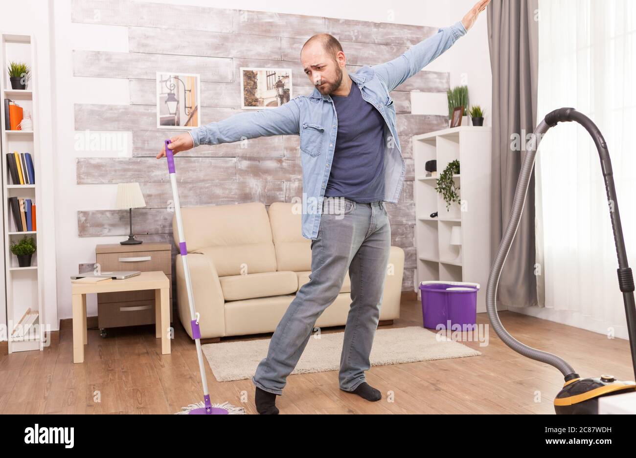Man dancing with mop while cleaning the house Stock Photo Alamy