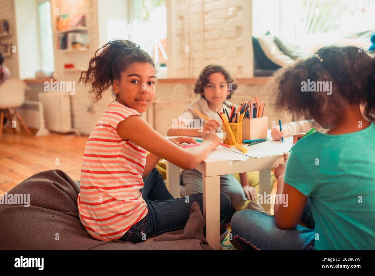 African-American girl drawing together with her peers Stock Photo