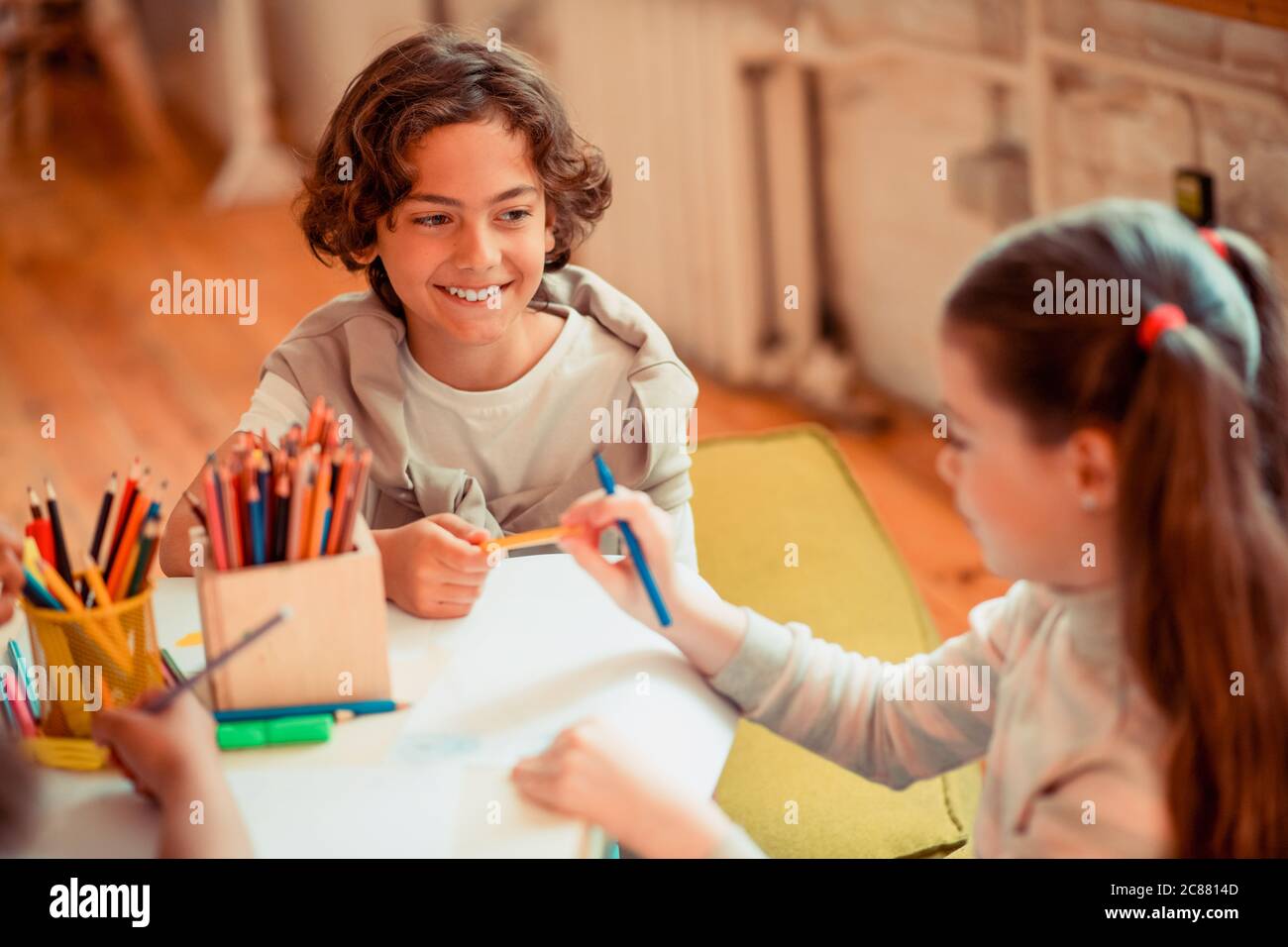 Boy sharing a color pencil with a girl Stock Photo
