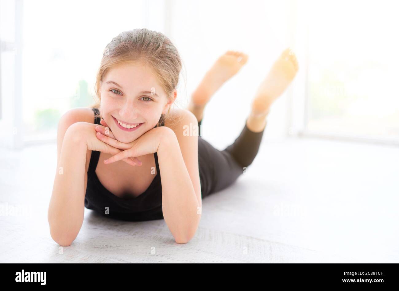 Cute smiling teenager girl lying on a floor in light room Stock Photo ...