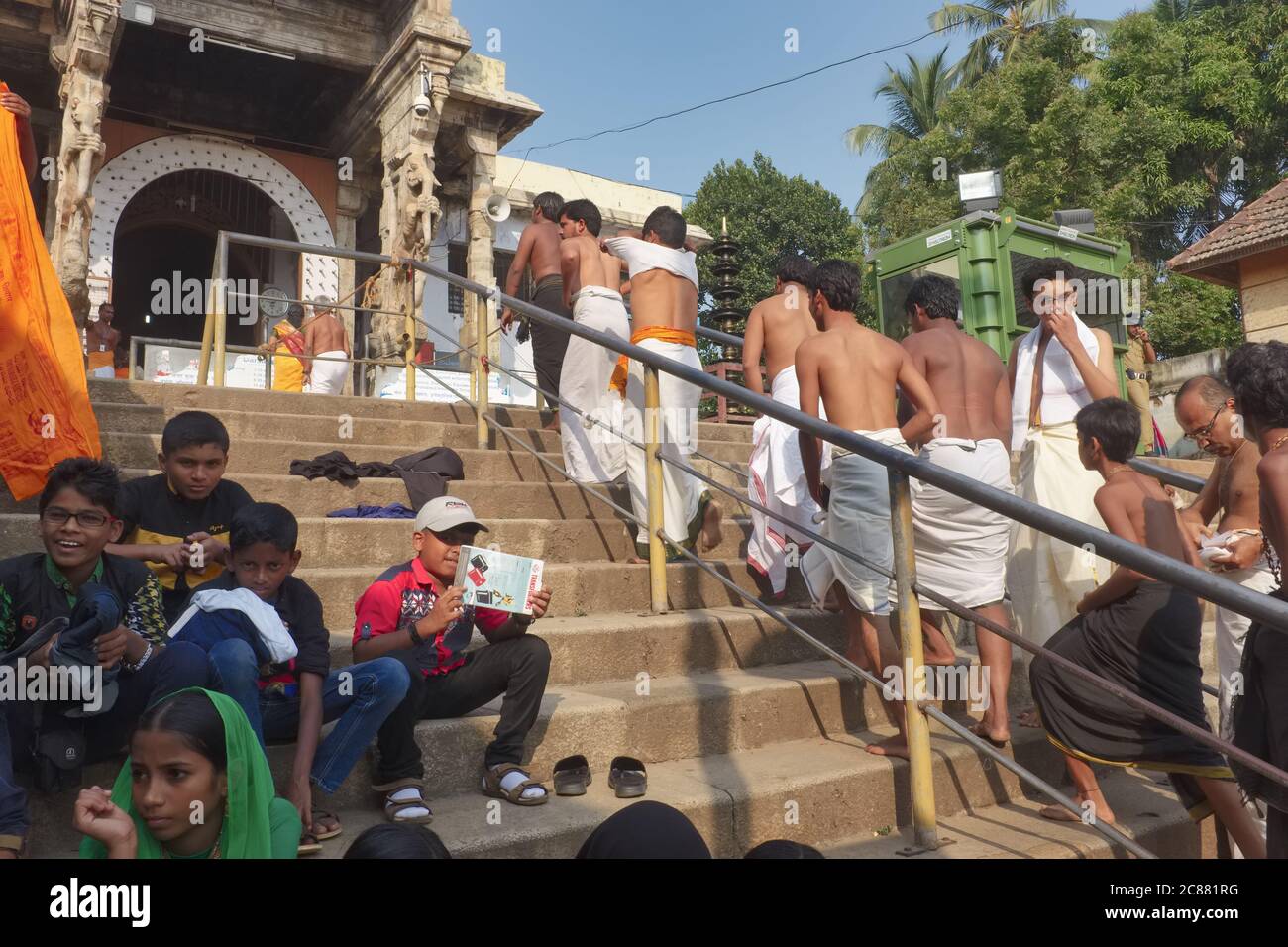 Hindu pilgrims in white loinslothes ascending the stairs to Padmanabhaswamy Temple in Trivandrum (Thiruvananthapuram) in Kerala, India Stock Photo