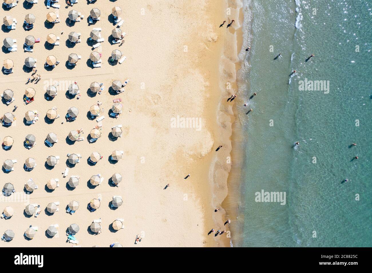 Aerial view of a shallow sandy beach and sunshade with sun umbrellas. Tourism and holiday concept. High quality photo Stock Photo
