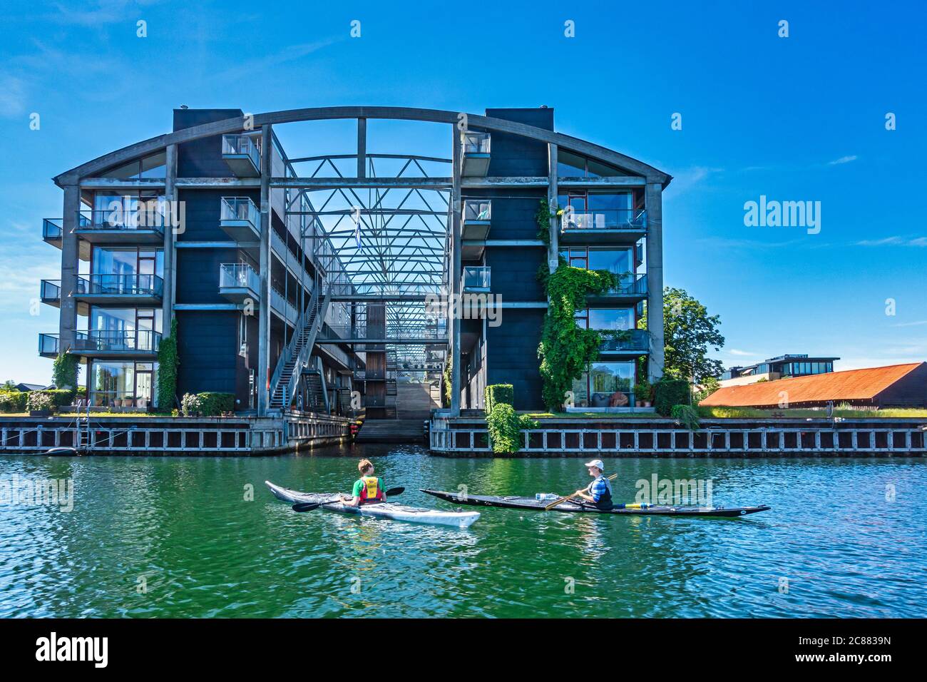 Kayaks passing Building with flats at Bohlendachvej Holmen Copenhagen harbour Copenhagen Denmark Europe Stock Photo