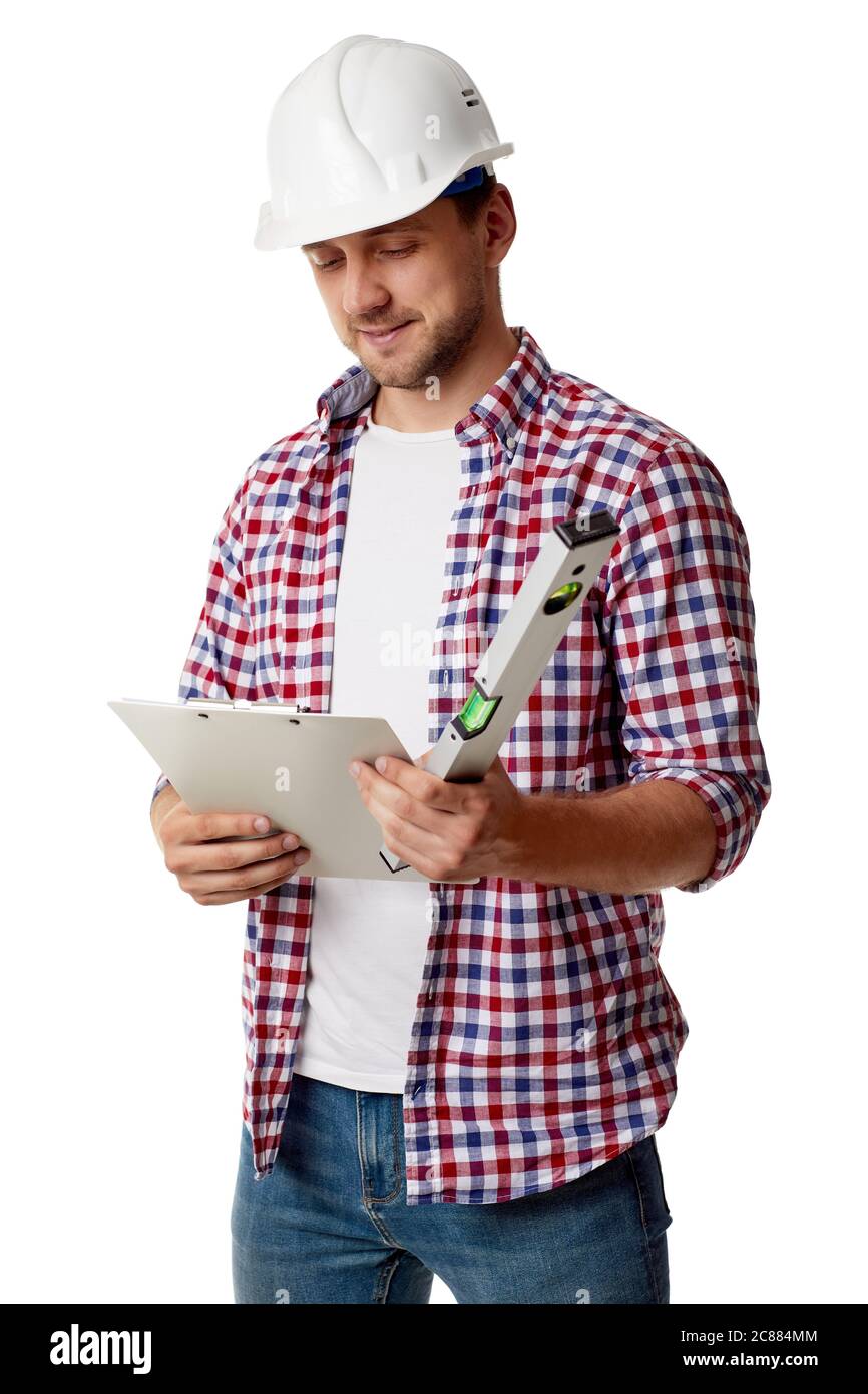handyman worker in hard hat reads details of an order. builder in shirt with builder level and clipboard isolated on white studio background Stock Photo