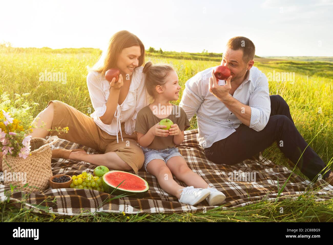 Happy family playing with apples on a picnic outdoors Stock Photo - Alamy