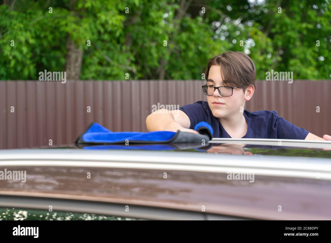 young guy washes a car with a rag. self wash machine Stock Photo
