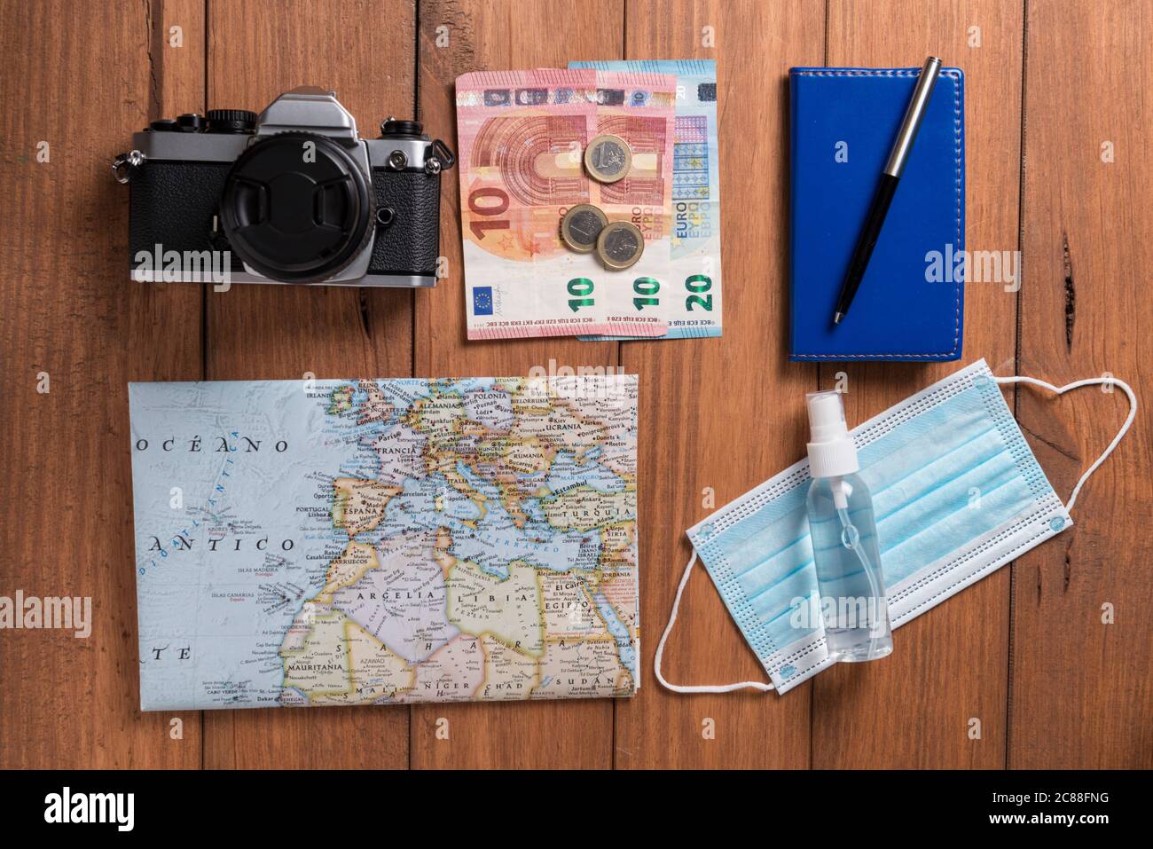 Conceptual still life with various objects related to travel and mask, on wooden boards. Travel concept during the covid19 coronavirus pandemic. Stock Photo