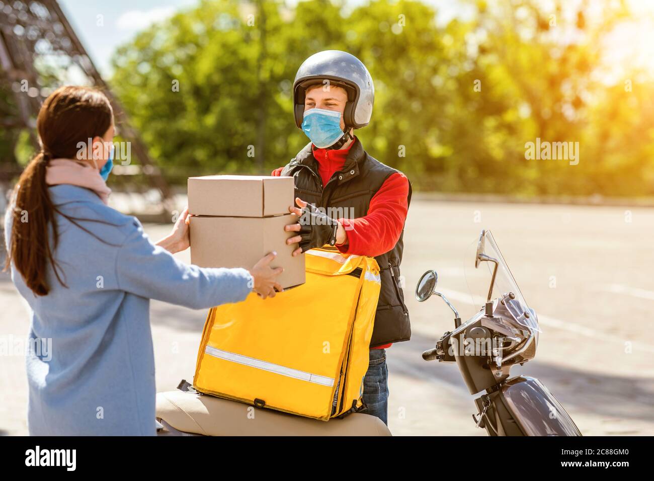 Delivery Guy Giving Food Boxes To Customer Girl Standing Outdoors Stock Photo