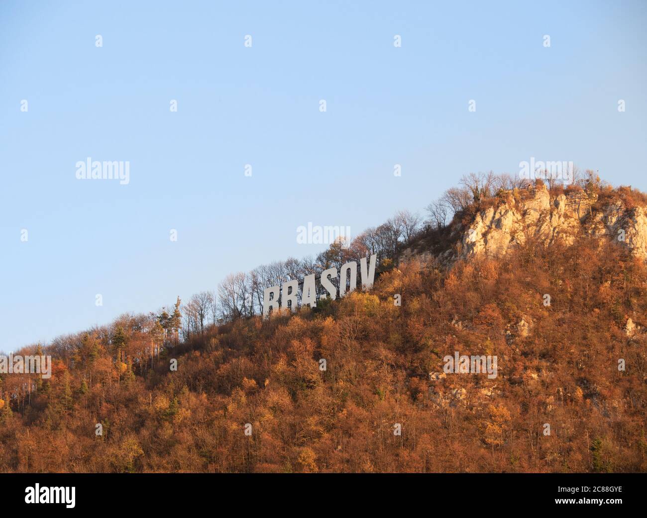 Brasov name, clearly seen on the mountain surrounded by autumn forest. Stock Photo