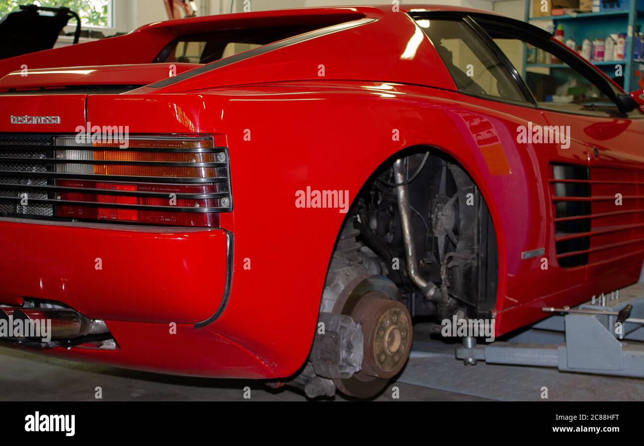 Photo of a Ferrari Testarossa jacked up with the wheels removed. Photographed from the back right. Stock Photo