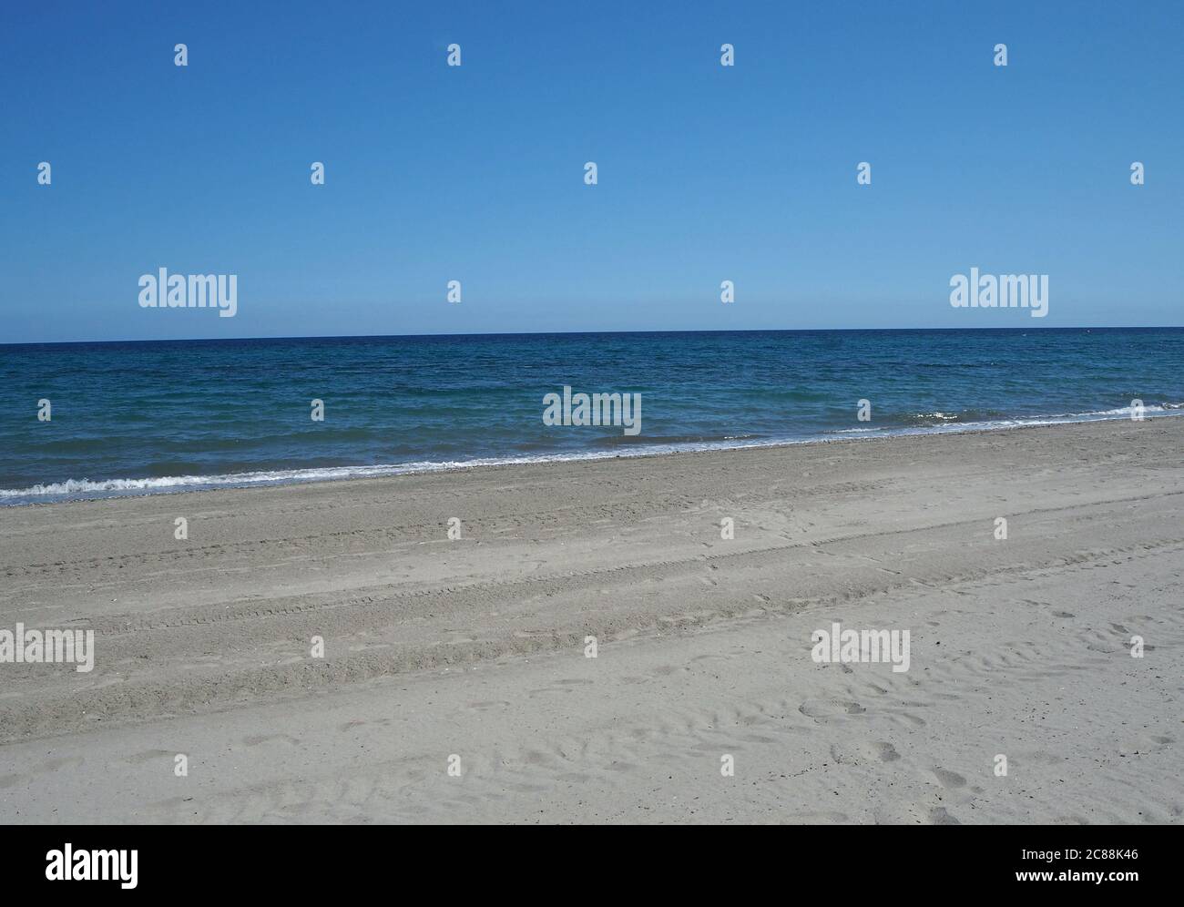 clean empty sand beach with blue sky and calm sea Stock Photo - Alamy