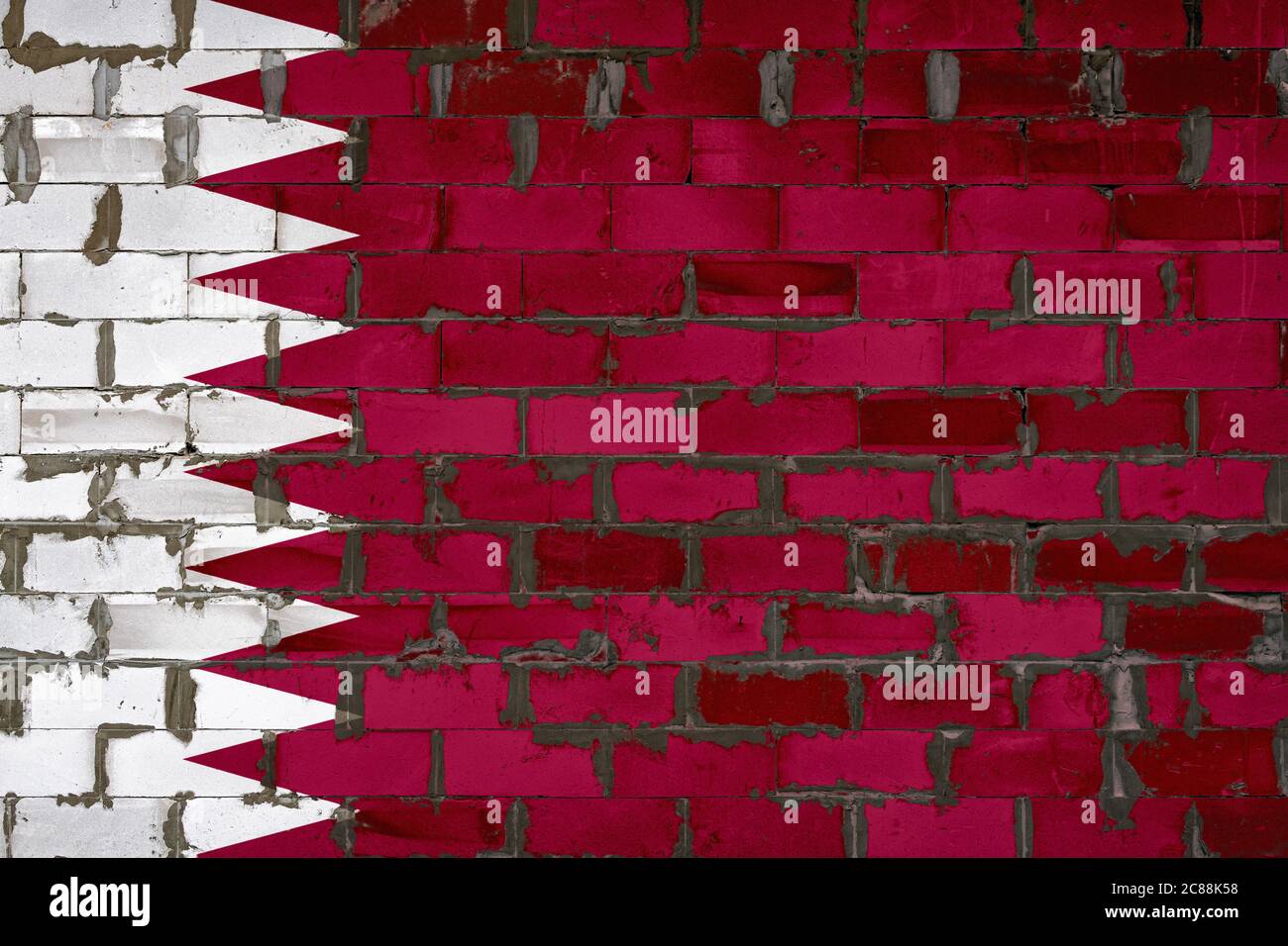 The national flag of Qatar painted on a wall of sibit blocks with ...